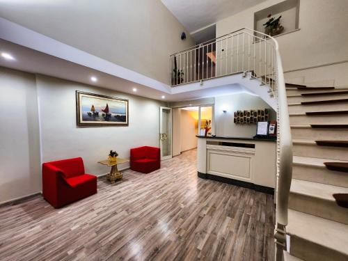 a lobby with a staircase and red chairs at Hotel Nazionale in Bolsena