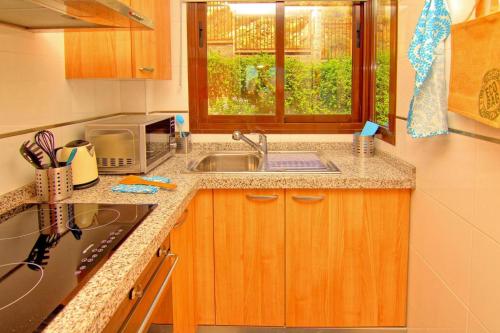 eine kleine Küche mit einem Waschbecken und einem Fenster in der Unterkunft Holiday flat Mijas Costa - COS02106b-P in Mijas Costa