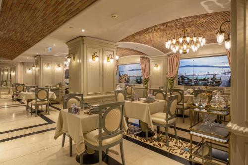 a restaurant with tables and chairs and a chandelier at MFB Tarabya Hotel in Istanbul