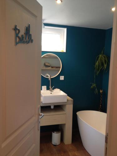 une salle de bain avec un lavabo, une baignoire et un miroir dans l'établissement Maison indépendante au pied du Ventoux, à Bédoin
