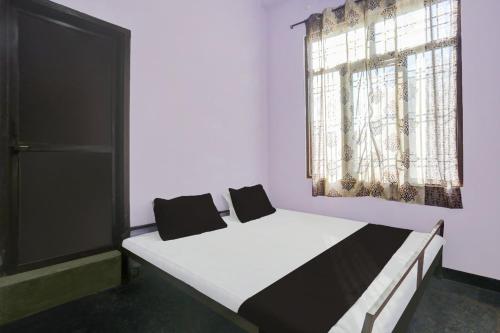 a bedroom with two beds and a window at OYO Flagship Aravali Guest House & Restaurant in Kishangarh