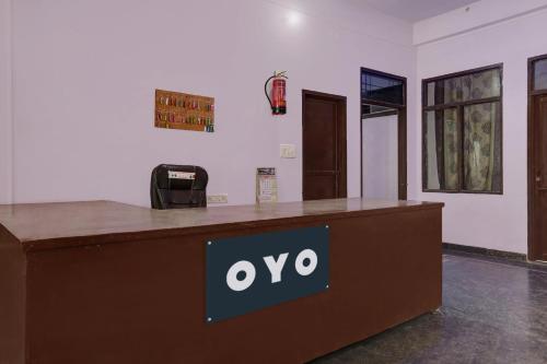 OYO Flagship Aravali Guest House & Restaurant في كيشانجاره: مكتب مكتب مع علامة على الوفو