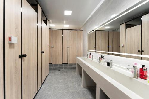 a bathroom with two sinks and wooden cabinets at Shisandufu Youth Hostel in Xi'an