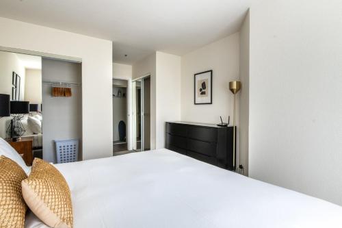 - une chambre avec un lit blanc et une commode dans l'établissement South Beach 1br w spa lounge nr baseball park SFO-1665, à San Francisco