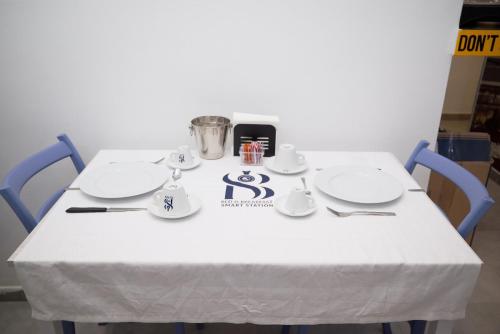 a table with a white table cloth and plates on it at B&B Smart Station Caserta in Caserta