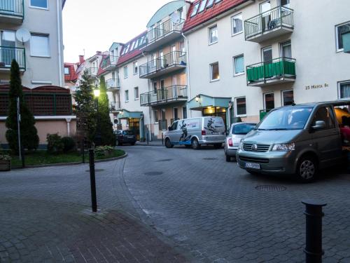 a street with cars parked next to tall buildings at Sopot Apartament in Sopot