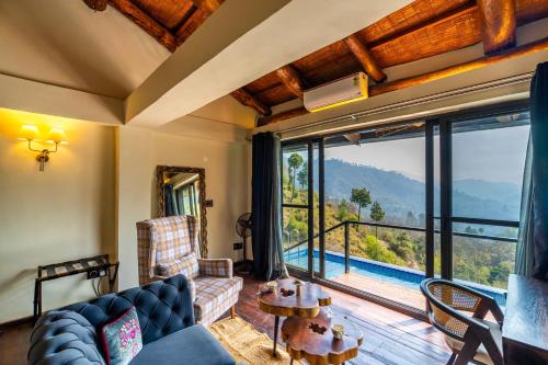 a living room with a couch and a table at StayVista at Leopard's Creek with Pool in Solan