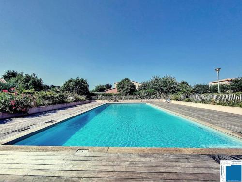 une piscine d'eau bleue et une terrasse en bois dans l'établissement Villa Pomelo - Jacuzzi - Piscine- Climatisation, à Lecci