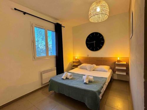 une chambre avec un lit et une horloge au mur dans l'établissement Villa Pomelo - Jacuzzi - Piscine- Climatisation, à Lecci