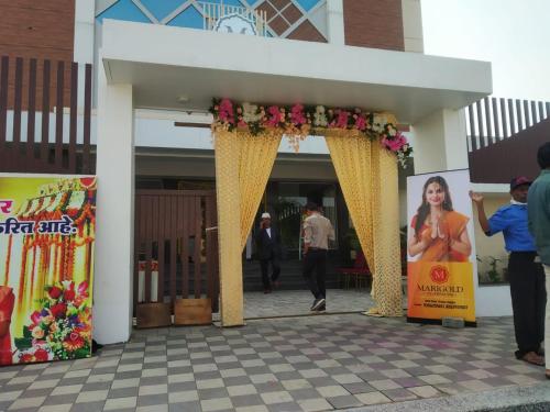 una entrada a un edificio con un arco amarillo con flores en Marigold Celebration hotel, en Rāipur