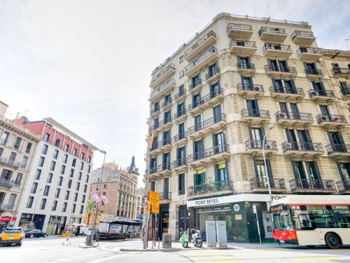 wysoki budynek przy ulicy miejskiej z autobusem w obiekcie Luxurious apartment for 9 people recently renovated in the center of Barcelona w Barcelonie