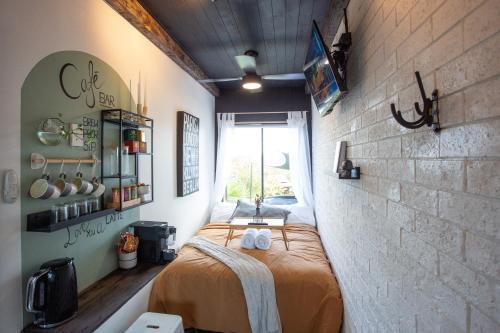 a bedroom with a bed in a brick wall at The Tiny Room on the lake in Rathmines