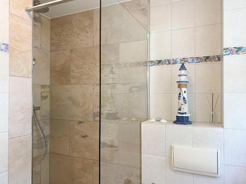 a shower with a glass door with a lighthouse on it at Achtern Diek 7b - Wohnung 8 in Groß Kirr