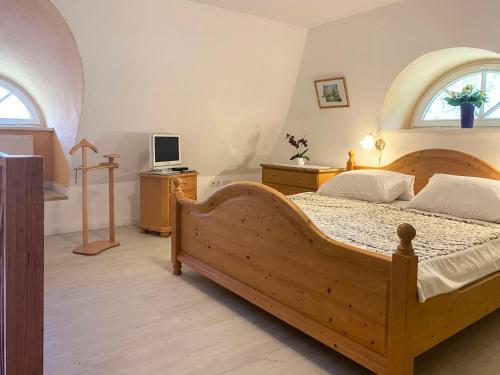 a bedroom with a wooden bed and a computer on a desk at Achtern Diek 7b - Wohnung 8 in Groß Kirr