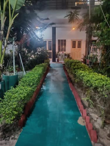 a pathway through a garden with blue water at Homestay Urmil Basant in Jaipur