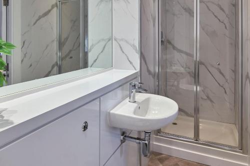 a white bathroom with a sink and a shower at Host & Stay - Ropewalks Quarters in Liverpool
