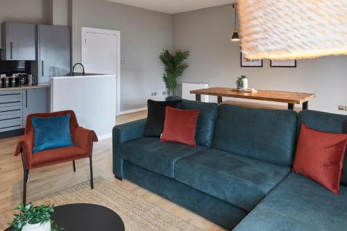 a living room with a blue couch and a kitchen at Host & Stay - Ropewalks Quarters in Liverpool