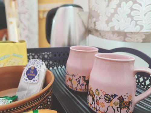 two pink vases sitting on a table at Homestay Urmil Basant in Jaipur