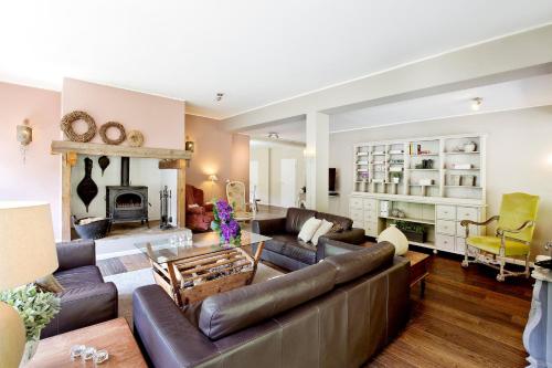 un salon avec un canapé et une cheminée dans l'établissement Westerwald Ferien Villa - 21 Personen - Kino, Bar, Sauna und Whirlpool, à Schutzbach