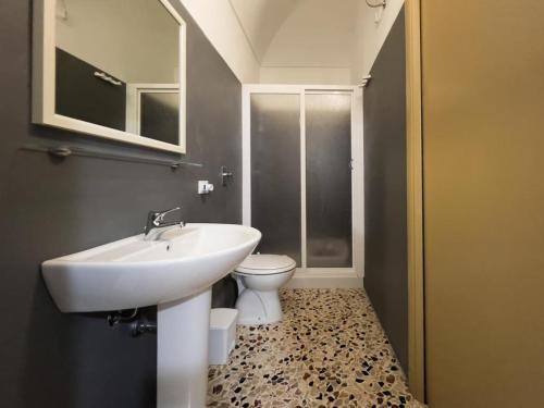 ein Bad mit einem Waschbecken und einem WC in der Unterkunft Isola Serena in Favignana