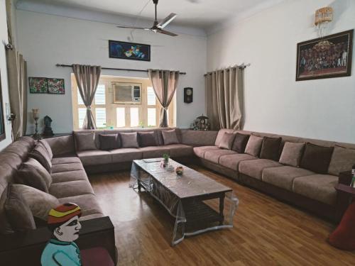 sala de estar con sofá y mesa de centro en Homestay Urmil Basant, en Jaipur