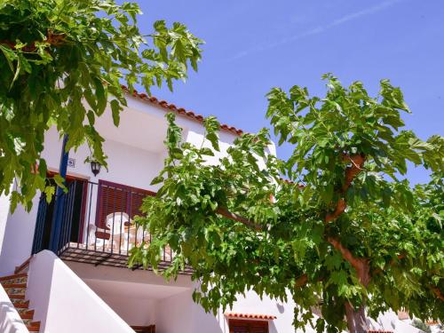 einen Baum vor einem weißen Gebäude mit Balkon in der Unterkunft Belvilla by OYO Apartment in Torreblanca in Torreblanca