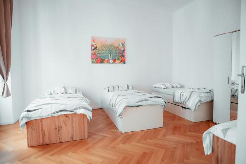 a room with two beds and a painting on the wall at Raimond Apartment Ottakring Top 14 in Vienna