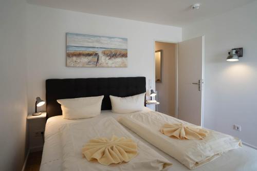 a bedroom with a large white bed with two pillows at Musical in Westerland