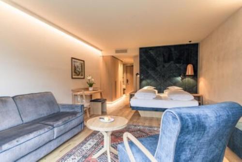 uma sala de estar com um sofá e uma cama em Hotel Pacherhof em Bressanone