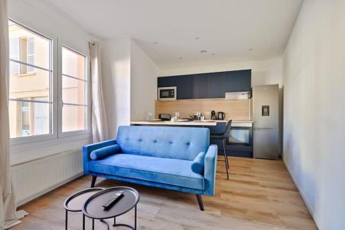 un salon avec un canapé bleu et une cuisine dans l'établissement Welcome to Lucie House, à Marly-le-Roi