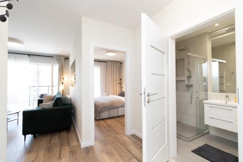 a room with a bedroom and a bathroom with a bed at Glow Apartments, Letnica - Apartamenty Bursztynowa Zatoka&Przystań Letnica in Gdańsk