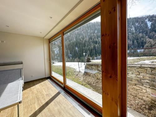 a room with a large window with a view at Locanda Orelli in Bedretto