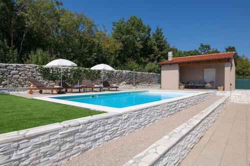 een zwembad in een tuin met een stenen muur bij Holiday Home Asteria - Happy Rentals in Labin