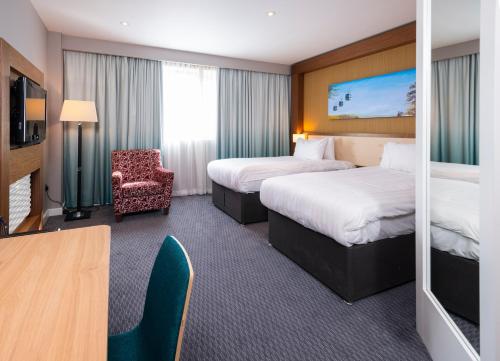 una camera d'albergo con due letti e una sedia di Holiday Inn Derby Riverlights, an IHG Hotel a Derby