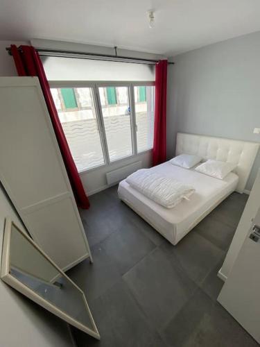 - une chambre avec un lit blanc et une fenêtre dans l'établissement RDC proche gare et port, au Croisic