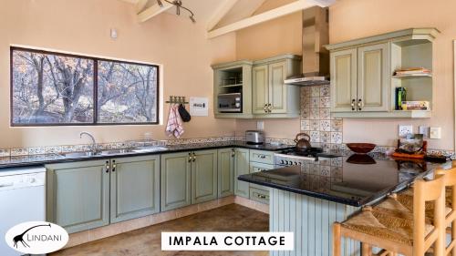 a kitchen with green cabinets and a window at Lindani Game and Lodges in Vaalwater