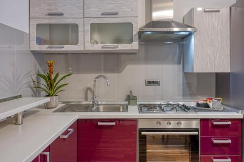 a kitchen with red cabinets and a sink at Apartments Suki in Rovinj