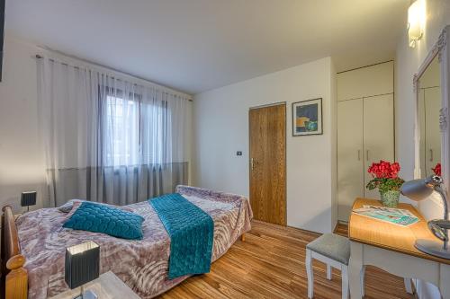 1 dormitorio con cama, escritorio y mesa en Apartments Suki, en Rovinj