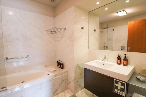 uma casa de banho com uma banheira e um lavatório e uma banheira em Refúgio Rio Douro em Porto