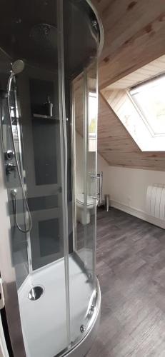 a shower in a room with a ceiling with a window at La maison in Tarnac