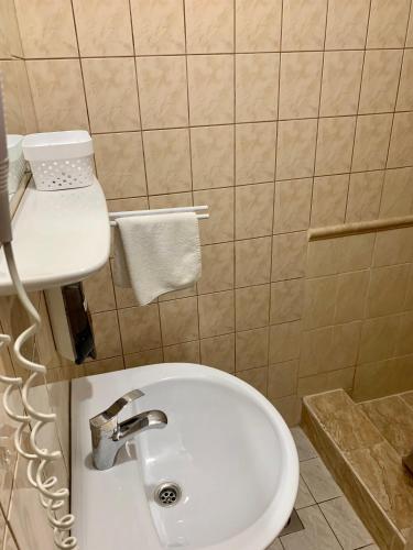 a bathroom with a white sink and a toilet at Aranykorona Hotel in Miskolc