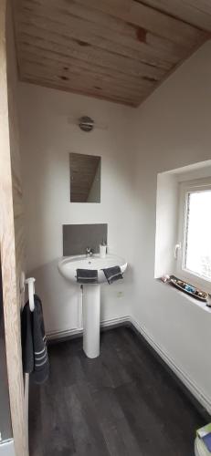 a bathroom with a white sink and a window at La maison in Tarnac