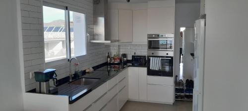 ネルハにあるMiami 4º5の白いキッチン(シンク、冷蔵庫付)