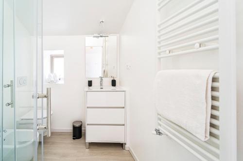Baño blanco con lavabo y espejo en Maison Bohémienne, en Trieste