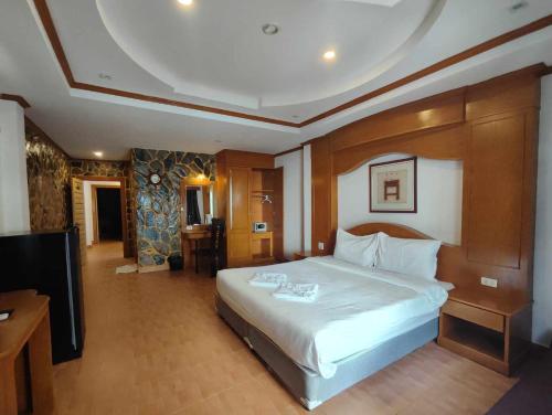 a bedroom with a large bed and a flat screen tv at Rock Shore Patong in Patong Beach