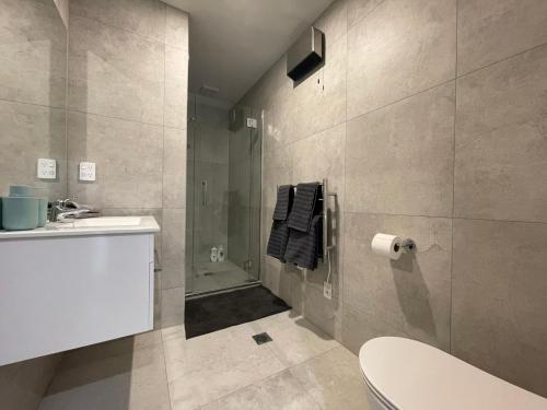 a bathroom with a shower and a toilet and a sink at Stadium View Suite in Christchurch
