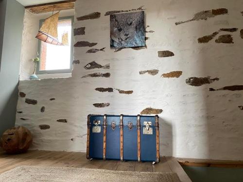 a room with a blue suitcase in front of a wall at La Maison de Mano in Plouër-sur-Rance