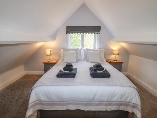 a bedroom with a bed with two towels on it at Beau Cottage in Bewdley