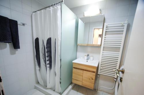 La salle de bains est pourvue d'une douche et d'un lavabo. dans l'établissement Nomad apartments, à Skopje