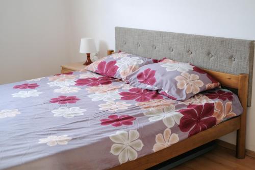- un lit avec des fleurs roses et blanches dans l'établissement Nomad apartments, à Skopje